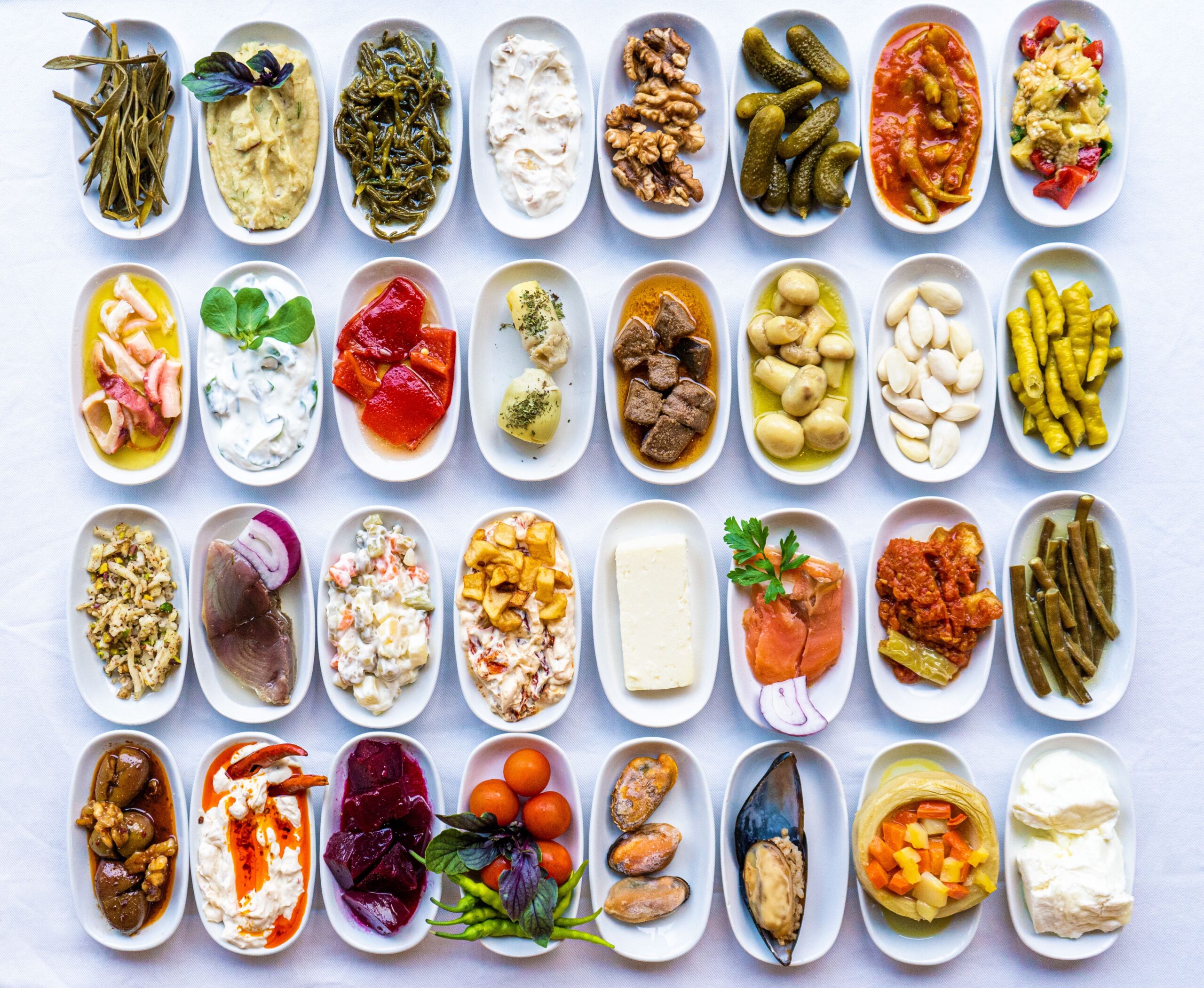 A vibrant display of traditional Turkish meze dishes on a white tablecloth, showcasing authentic flavors.